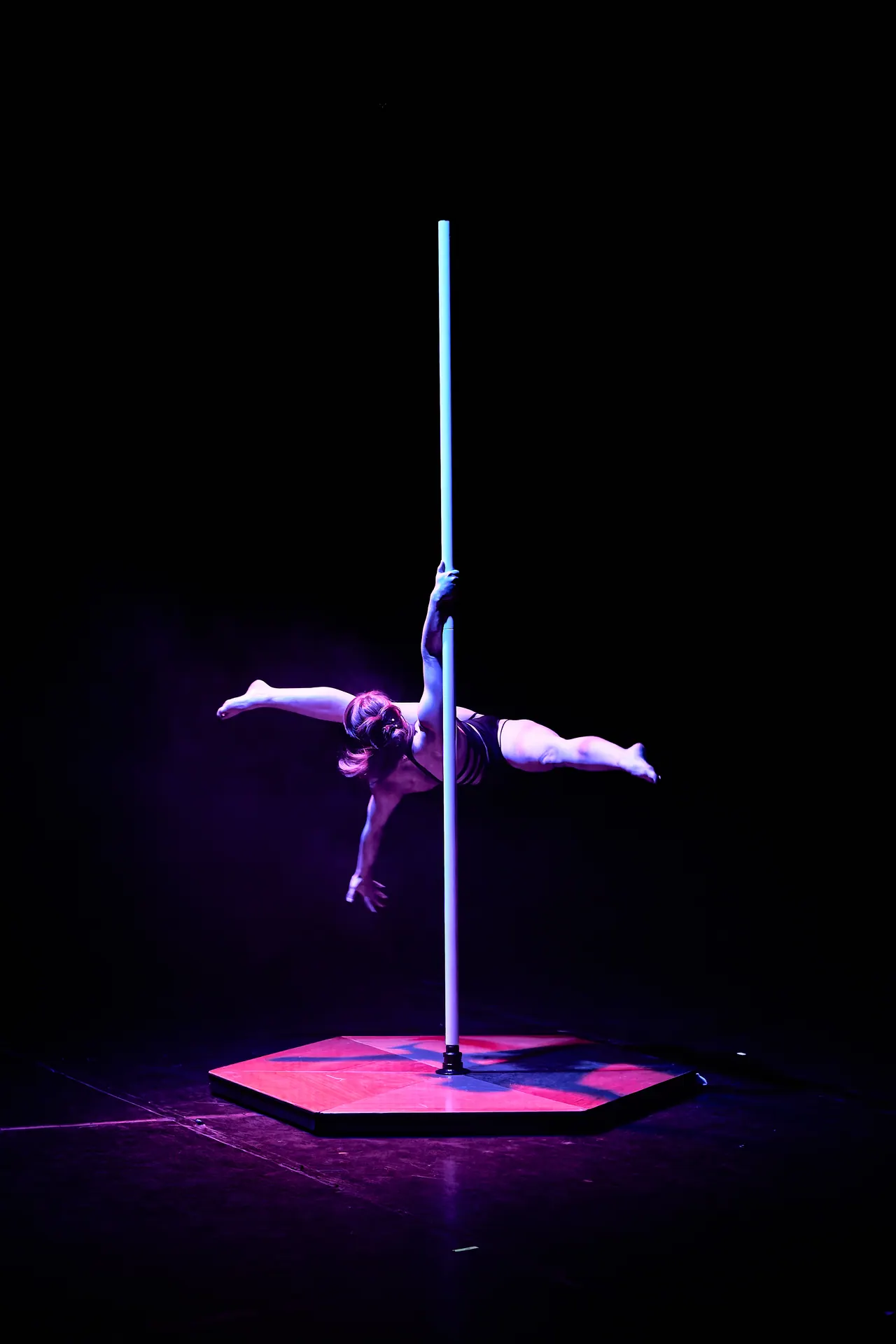 Sportivă în timpul unui număr de pole pe scena unei competiții